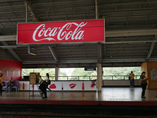 Coca-Cola logo with a glass of Coca-Cola in front of a global backdrop